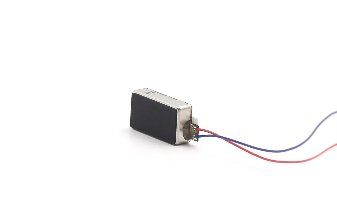Perspective view showing the top dampening foam surface and compact stainless steel housing of the linear haptic feedback actuator.