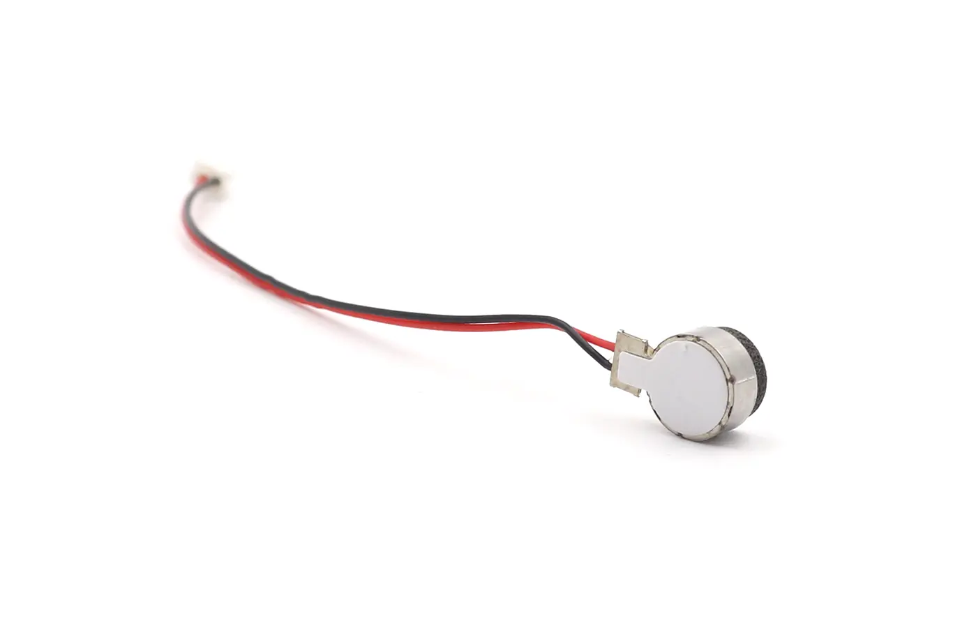 LRA haptic feedback motor showing flexible wire leads and white adhesive backing liner
